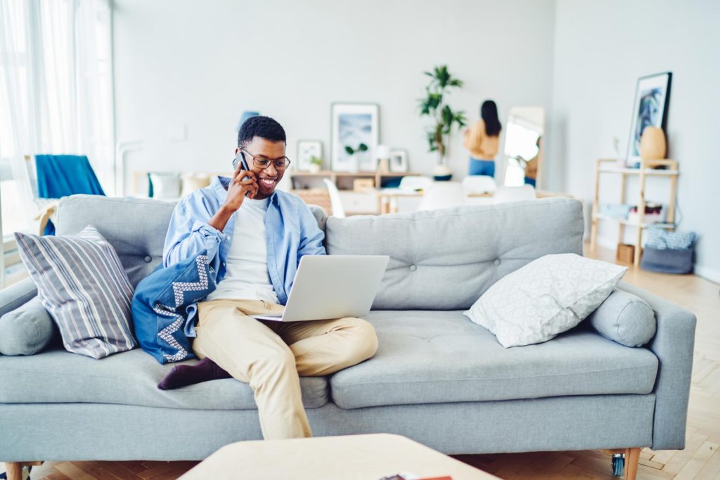 Man sitting on couch on call and working